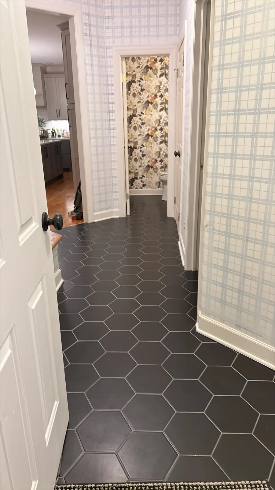 A hallway floor in dark hexagon tile