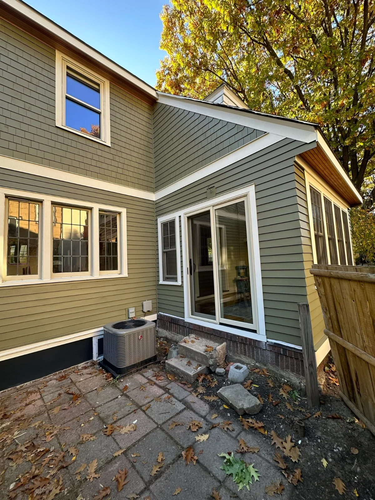 A house’s green shingle siding and white trim, freshly painted